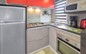 a small kitchen with a stove and a sink at Mobile-Home Proche Mer 400M in Grandcamp-Maisy