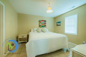 a bedroom with a white bed and a window at Cg Beach Bungalow #3 in Myrtle Beach