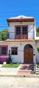 a small white house with a large wooden door at Casa Campana in Concepción de Ataco