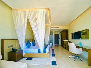 a bedroom with a bed with a canopy at Matemwe Sands Beach Resort in Mkuyuni Pwani