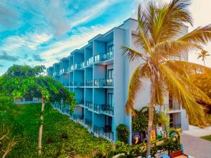 a blue building with a palm tree in front of it at Matemwe Sands Beach Resort in Mkuyuni Pwani