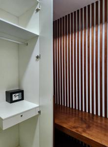 a closet with a wooden partition with a clock on a shelf at Torre Yaxche Urban Center in Cancún +30 photos