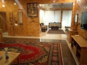 a living room with a large rug and a living room with a couch at Gahirat Castle Chitral in Chitral