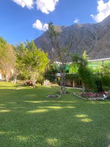 a yard with a house and mountains in the background at Gahirat Castle Chitral in Chitral +18 photos
