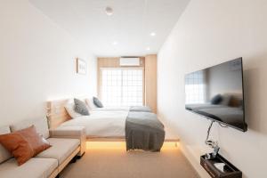 a bedroom with a bed and a couch at b&黒門3号店 in Osaka