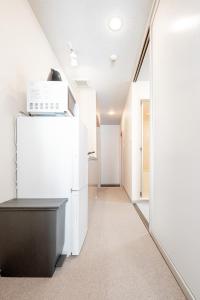 a hallway with a white refrigerator and a mirror at b&黒門3号店 in Osaka