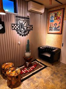 a living room with a leather couch and a wall with a nascar sign at ガレージホテルBeat in Nasushiobara