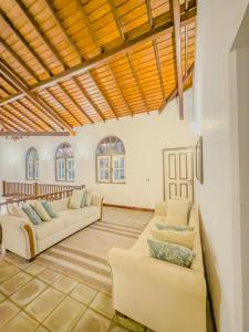 a living room with couches and a wooden ceiling at Villa House in Miriswatta