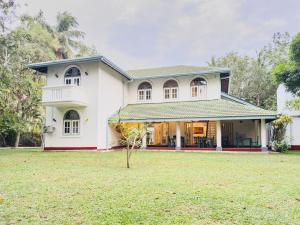 a white house with a large yard at Villa House in Miriswatta