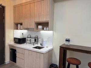a kitchen with a sink and a microwave at Inap II, Suterabay By Ayuhouz in Kota Kinabalu