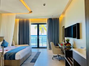 a hotel room with a bed and a desk with a computer at Matemwe Sands Beach Resort in Mkuyuni Pwani +130 photos