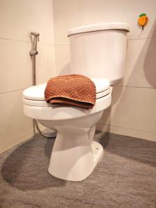 a bathroom with a toilet with a towel on it at TK Thongrak Apartment in Hat Yai +47 photos