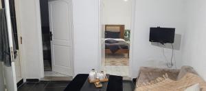 a living room with a mirror and a bedroom at Maison de vacance in Bin Rhilouf
