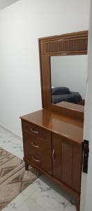 a wooden dresser with a mirror on top of it at Maison de vacance in Bin Rhilouf
