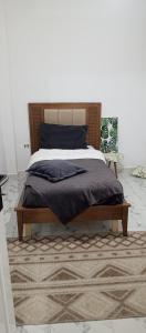 a bed with a wooden frame in a bedroom at Maison de vacance in Bin Rhilouf