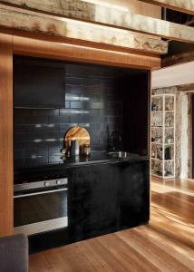 a black kitchen with a sink and a stove at The Barn Tasmania in Hobart