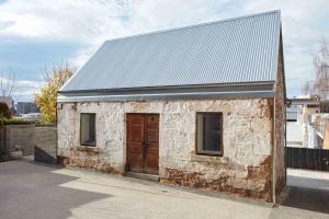 a small brick building with a large wooden door at The Barn Tasmania in Hobart