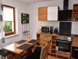 a kitchen with a wooden table and a microwave at Hammonds Jura Ferienwohnungen in Kasendorf