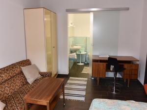 a living room with a couch and a desk at Hammonds Jura Ferienwohnungen in Kasendorf +10 photos