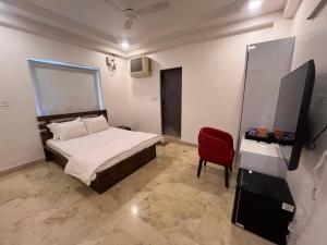 a bedroom with a bed and a red chair at Urban Nest in Nagpur