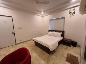 a small bedroom with a bed and a red couch at Urban Nest in Nagpur +7 photos