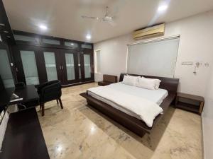 a bedroom with a bed and a desk and a chair at Urban Nest in Nagpur