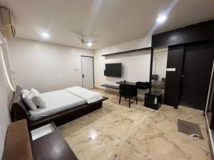 a hotel room with a bed and a television at Urban Nest in Nagpur
