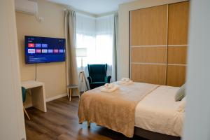 a hotel room with a bed and a tv at Beautiful new studios&apartments super central location in Bucharest