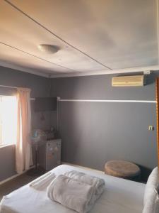 a bedroom with a white bed with a window at Dne Blue Star in Klerksdorp