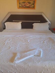 a large white bed with white sheets and pillows at Dne Blue Star in Klerksdorp
