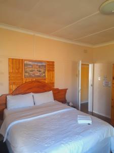 a bedroom with a large bed with a book on it at Dne Blue Star in Klerksdorp