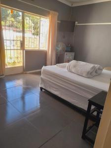 a bedroom with a bed and a large window at Dne Blue Star in Klerksdorp