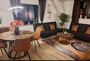 a living room with a black couch and a table at Parva Domus XL in Xanten