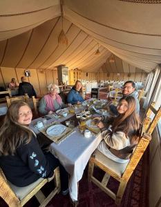 a group of people sitting at a table in a tent at Sahara Gift camp in Merzouga