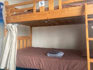 a bedroom with a bunk bed with a wooden ladder at BigJoy IN 2000 男性専用ドミトリーレンタル店2F ONLY MEN in Miyako-jima