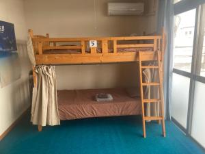 a bunk bed with a ladder in a room at BigJoy IN 2000 男性専用ドミトリーレンタル店2F ONLY MEN in Miyako-jima