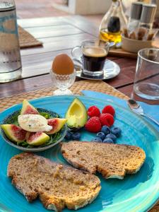 a blue plate with toast and fruit on a table at B&B Casa Luz del Sur, adults only in Alhaurín el Grande