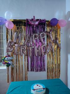 a table with a happy birthday sign and balloons at Sumathi homestay in Hospet