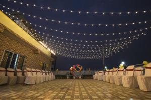 a banquet hall with tables and chairs and lights at Lotus Leaf GuestHouse in Guwahati