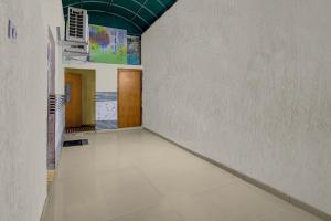 an empty room with a white floor and a wall at FabHotel Aavkar in Sātej
