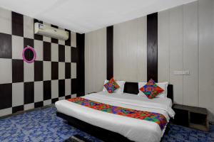 a bedroom with a large bed with colorful pillows at FabHotel Aavkar in Sātej