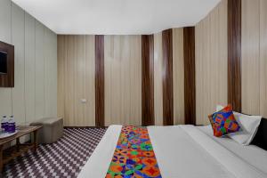 a hotel room with a bed with a colorful pillow at FabHotel Aavkar in Sātej +23 photos