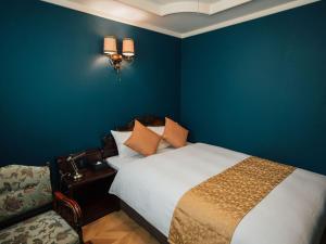 a bedroom with a bed and a blue wall at KANSEI null 佐賀 in Saga