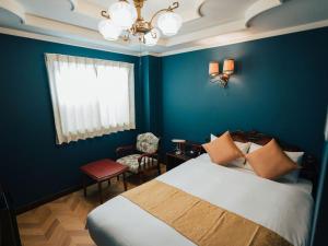 a bedroom with a bed and a blue wall at KANSEI null 佐賀 in Saga