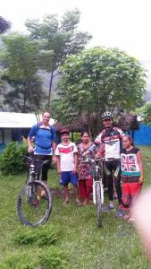a group of people standing with bikes in the grass at Riverside hostel in Ghanpokhara +67 photos