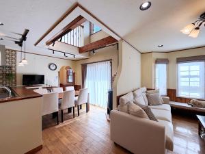 a kitchen and living room with a couch and a table at KOGUMA AKIRUNO villa in Akiruno