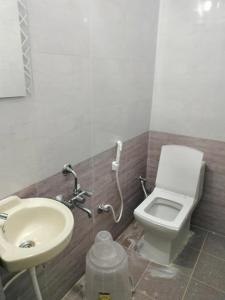 a bathroom with a toilet and a sink at ISIRI Rooms in Mysore