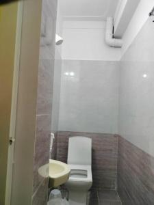 a bathroom with a white toilet and a sink at ISIRI Rooms in Mysore +12 photos