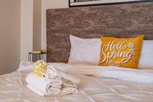 a white bed with a blanket and a yellow pillow at ARI Central Location in Arad