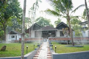 a house with a fountain in front of a yard at Neerbhoomi in Kollam